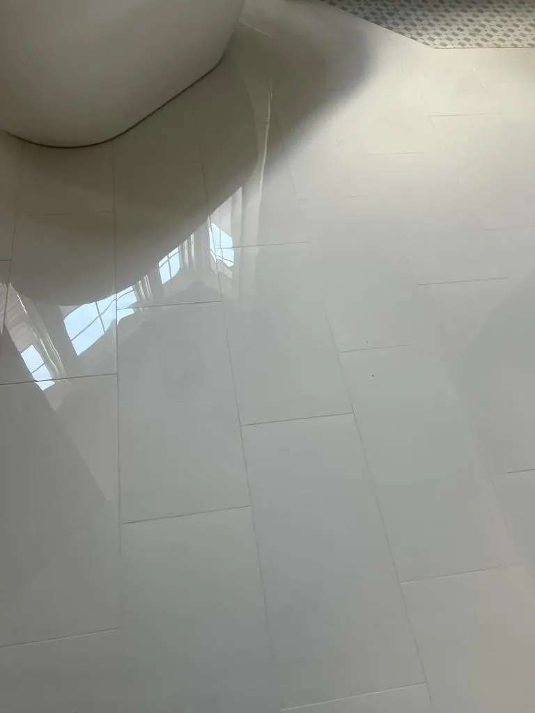 Bathroom renovation showing large format marble tile flooring installation with beautiful veining