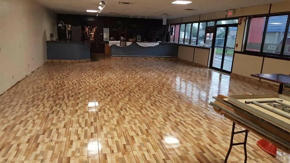 Large commercial gymnasium with professional wood flooring installation and high ceiling design