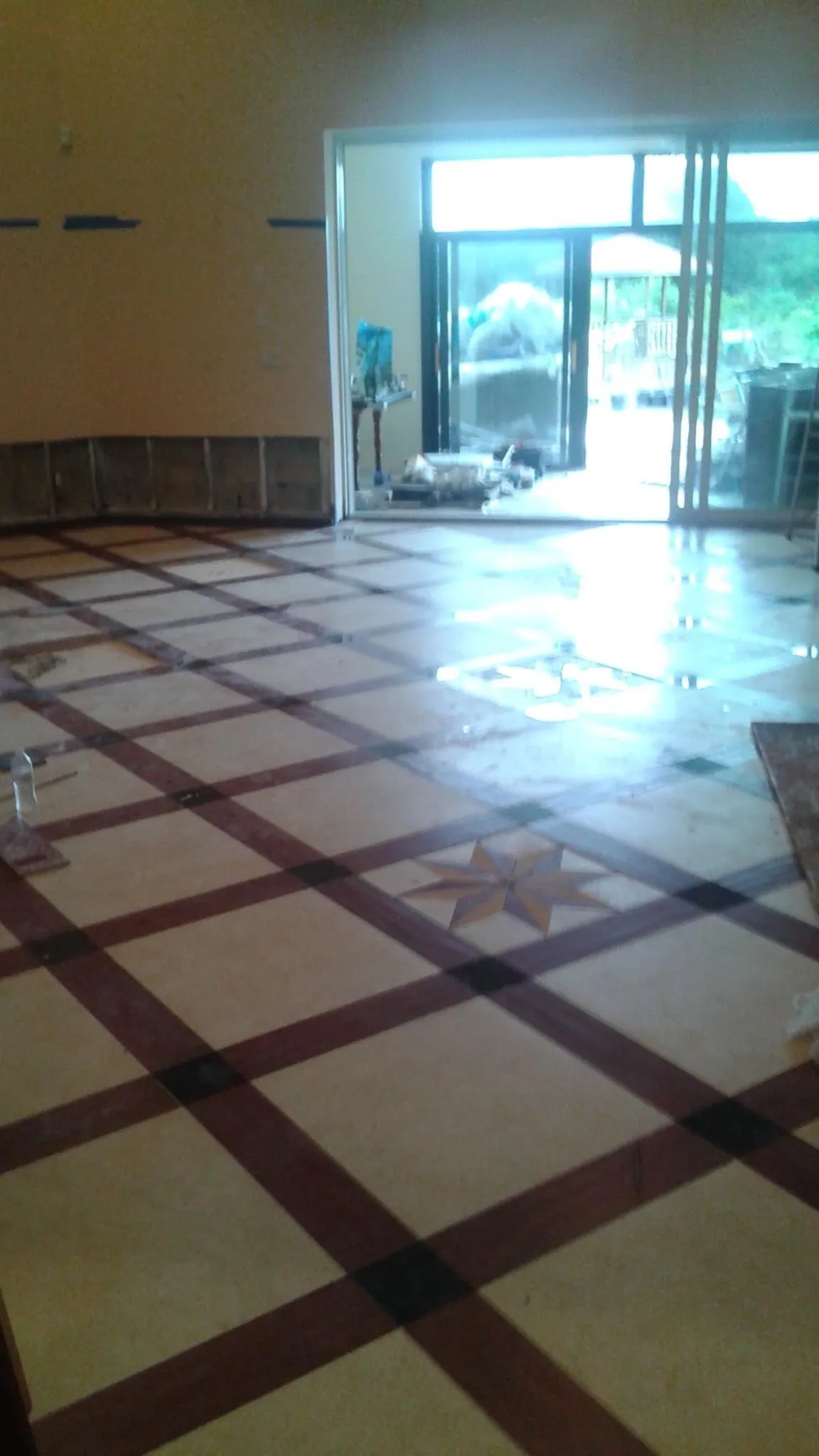 Custom decorative tile flooring with geometric star pattern in neutral tones showing detailed craftsmanship
