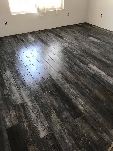 Work in progress showing dark wood plank flooring installation in residential space