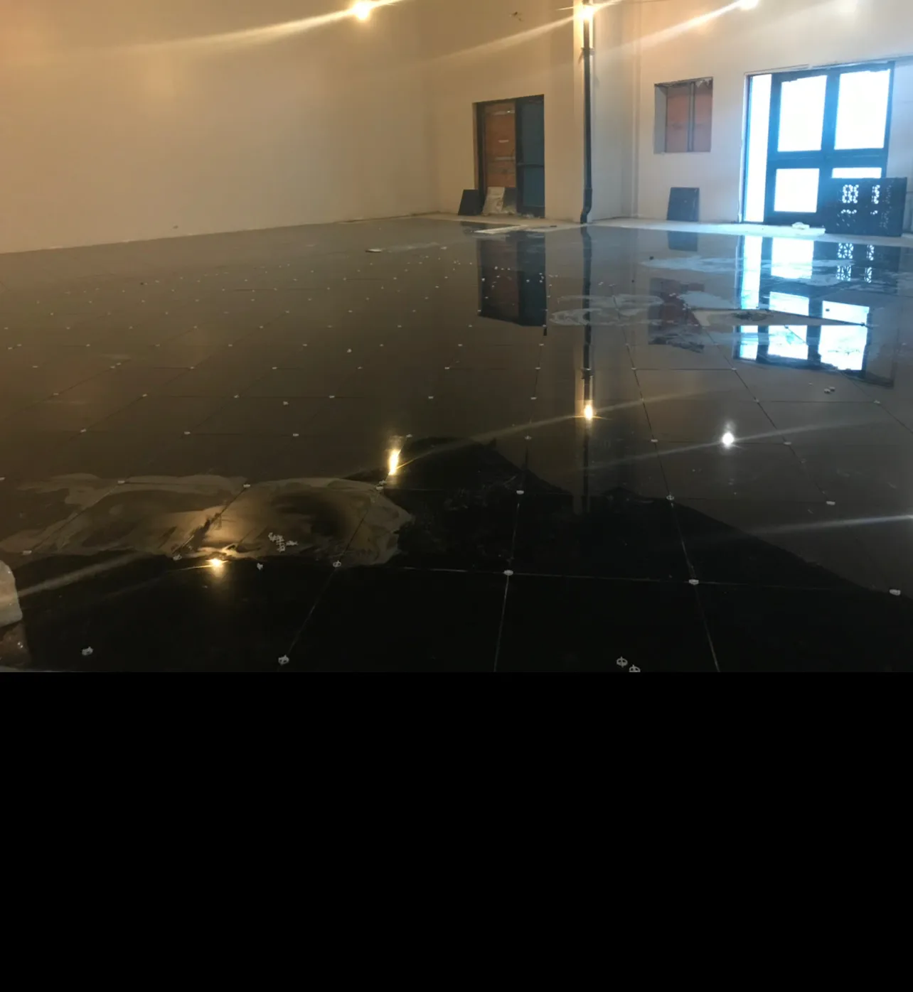 High-end bathroom with polished marble floors showing beautiful reflective properties and water reflection from recent work