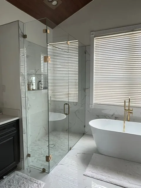 Luxurious master bathroom featuring glass-enclosed shower, wood plank ceiling detail, and modern freestanding tub