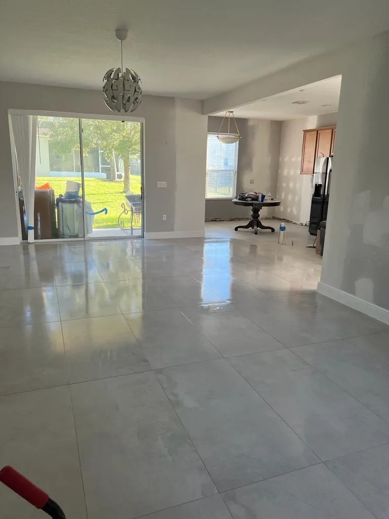 Contemporary living space with large format marble flooring, modern pendant lighting, and minimalist design