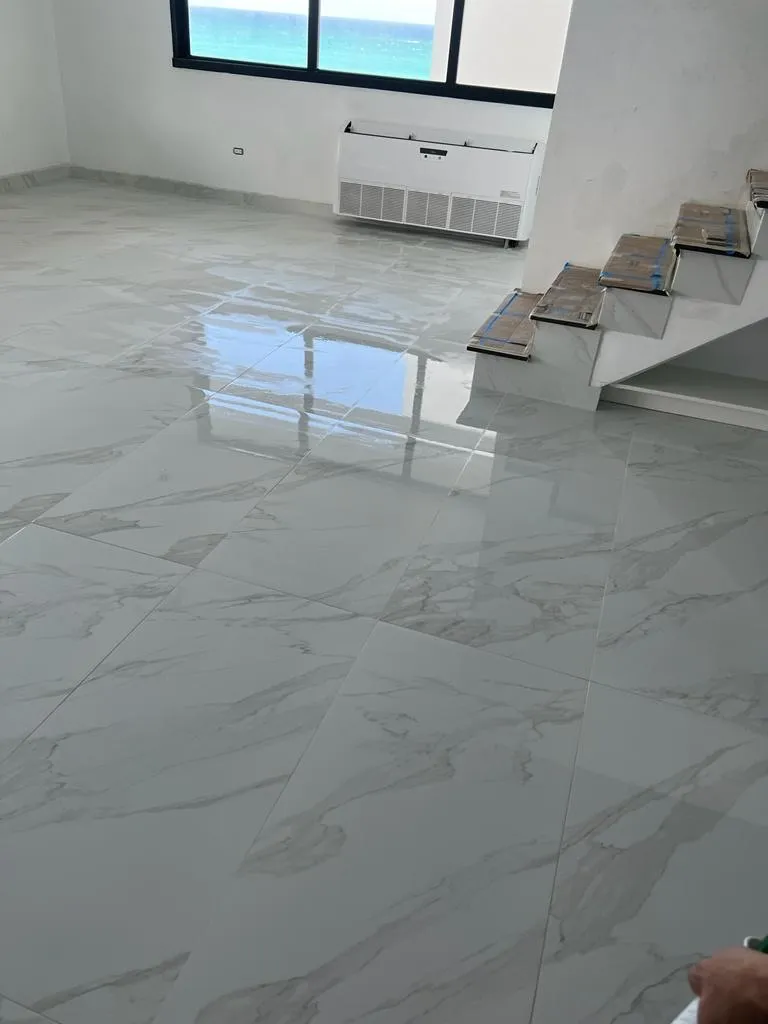 Room with stunning ocean view through large windows and marble flooring installation with tile samples