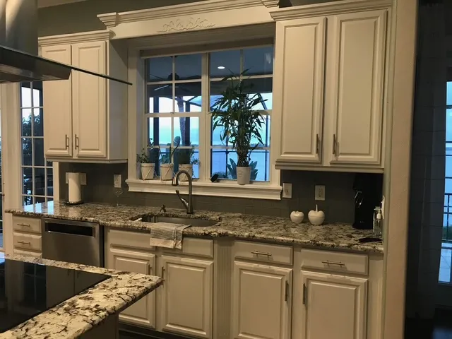 Classic kitchen design with white raised panel cabinets, granite countertops, and traditional styling